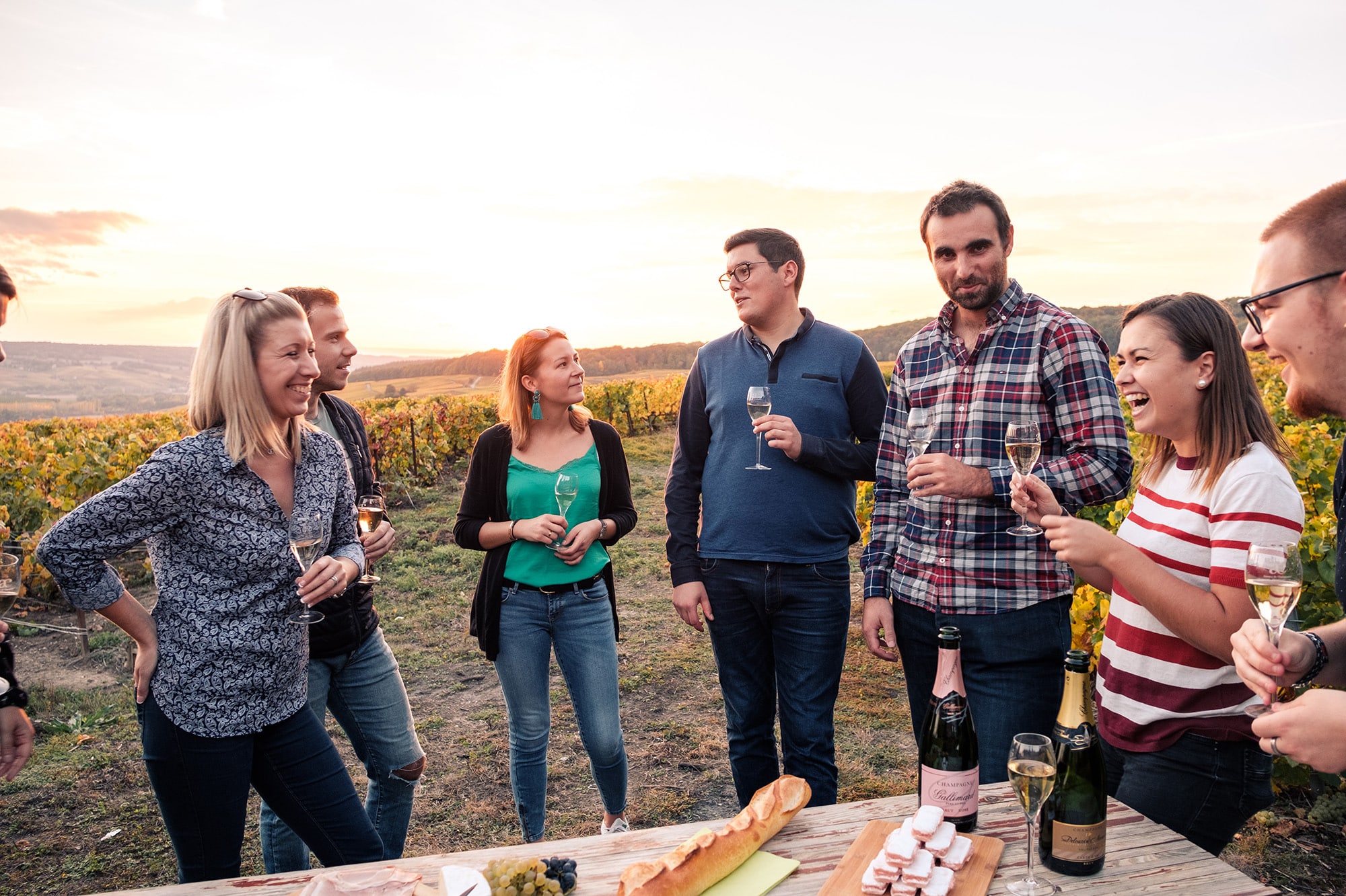 Groupe de jeunes qui prennent une flute de champagne dans le vignoble