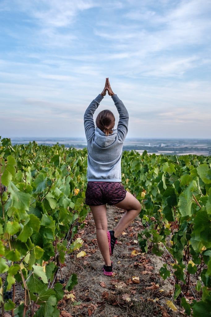 femme faisant du yoga dans les vignes