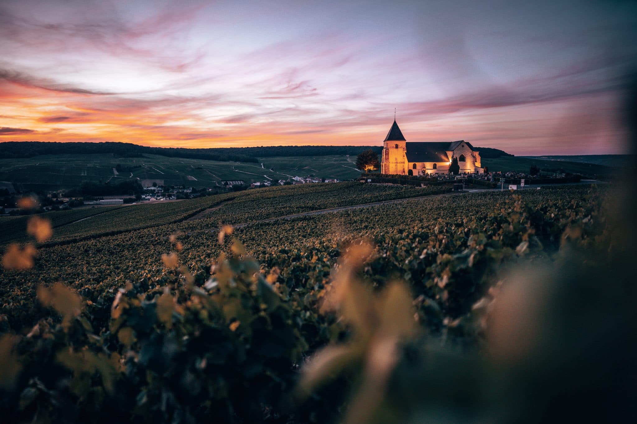Vue des vignobles sur une église à la tombée du jour - Epernay Tourisme